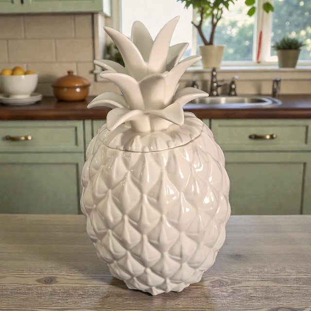 The Lenox Wicker Creek White Ceramic Pineapple Canister Cookie Jar is a stylish and functional kitchen storage item....