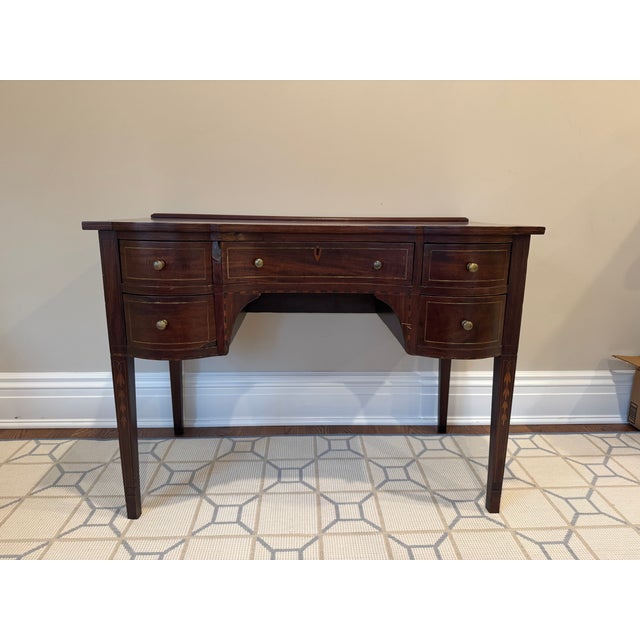 This elegant antique writing desk features a classic bow-front design and beautiful craftsmanship throughout. Made of...