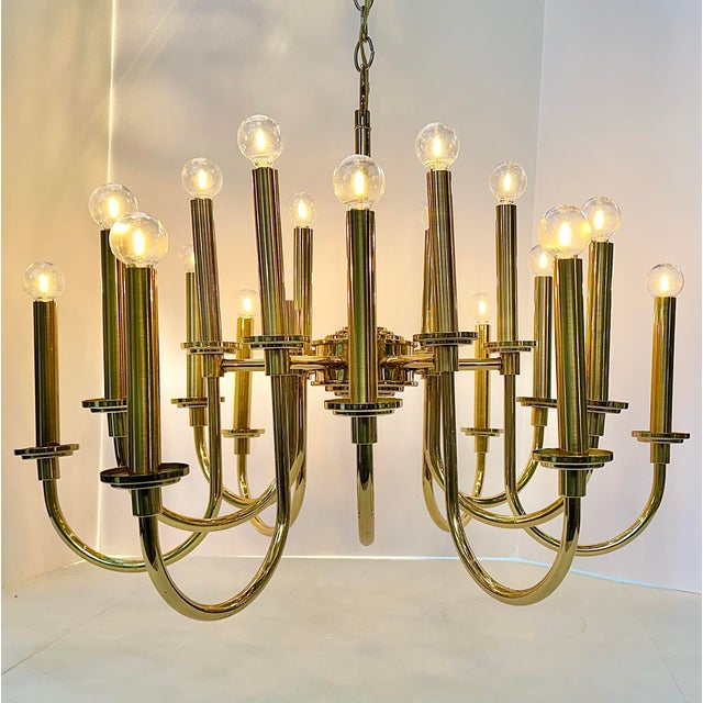 Very handsome vintage 18-light lacquered-brass chandelier in the style of Tommi Parzinger. The design features staggered...