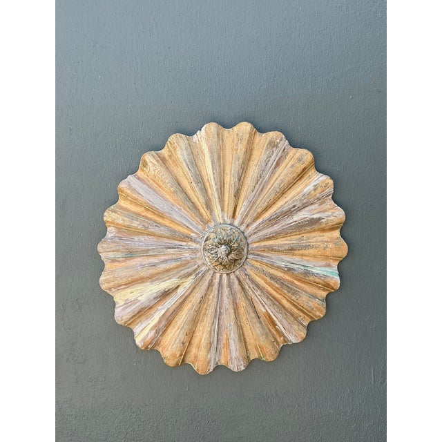 This vintage carved wood sunburst wall medallion is a sculptural decorative accent with a strong mid-century presence....