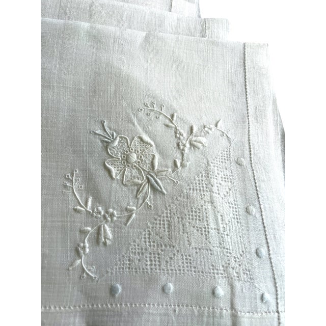 Set of 11 fine white linen napkins each measuring approximately 15 inches square. Expertly crafted, each napkin features a...