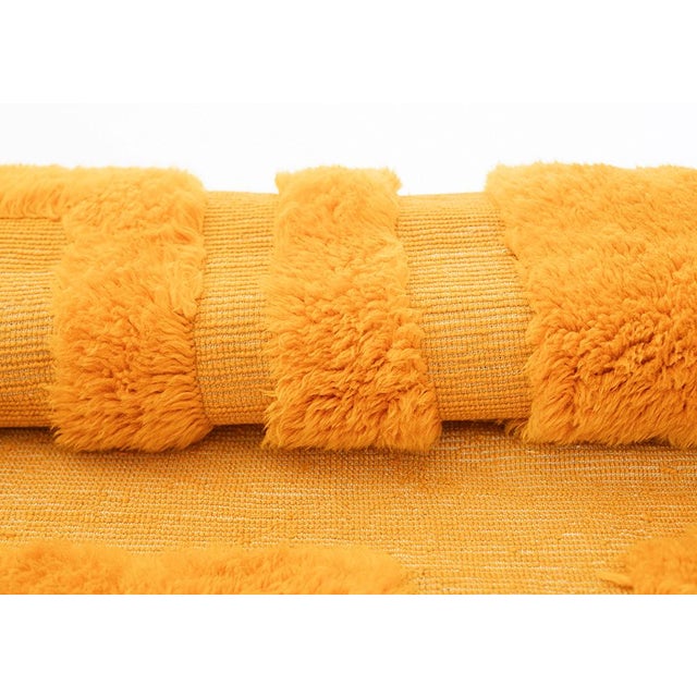 Vibrant hand-knotted wool rug in rich Saffron Gold with subtle abstract geometric patterns. This dynamic piece brings...