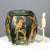 Tin box with polychrome chinoiserie decoration on a black background depicting birds, lanterns, branches, and plant...