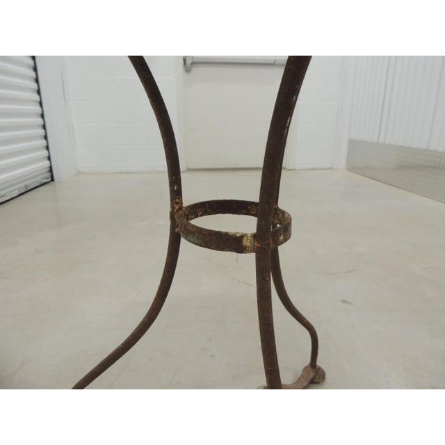 French Antique Wrought Iron Bistro Round Table. Round repousse top with jagged edge on top from age. Trypot legs, very...