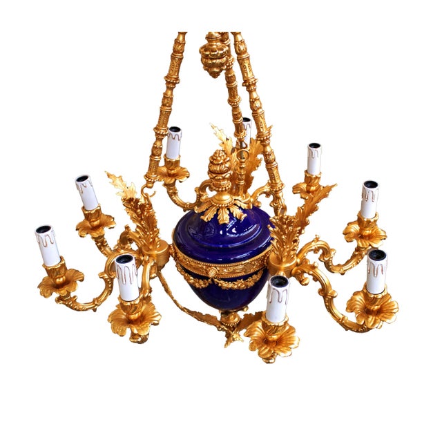 Elegant baroque style pendant chandelier made of 24kt gilt bronze. The central body in cobalt blue porcelain, the nine...