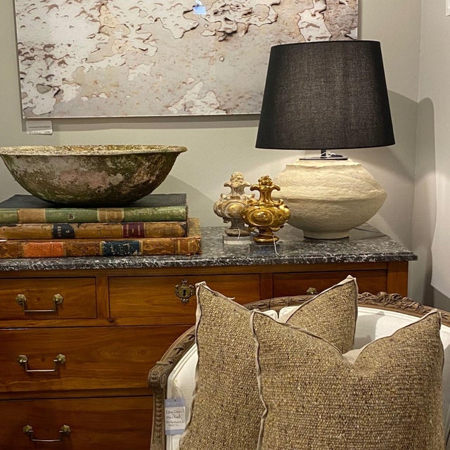 This custom paper mâché table lamp features a sculptural, organic silhouette with a naturally textured, off-white finish....