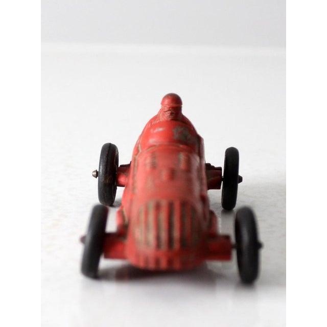 A vintage Auburn Rubber Co. USA 536 toy car. This Indy racer car has a red patinated body with black wheels.