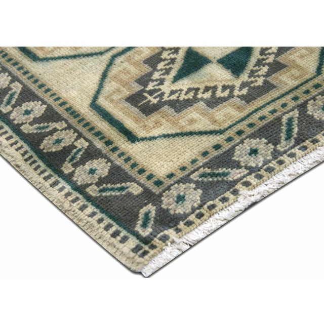 This vintage Turkish Oushak Yastic, measuring 1'7" x 2'5", is handwoven with wool on a wool foundation in Western Turkey’s...