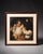 A classic portrait-style framed wall art piece with a warm traditional composition, cream matting, and a dark brown wood...