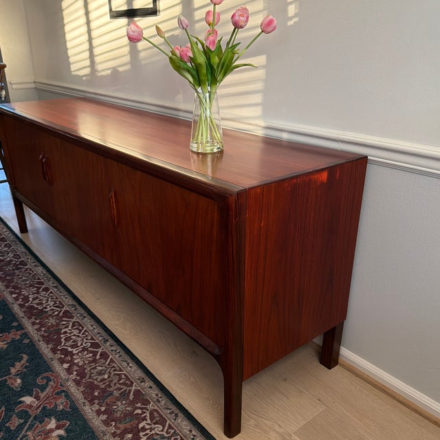 A timeless Danish Mid-Century Modern rosewood sideboard, showcasing the clean lines, exceptional craftsmanship, and...