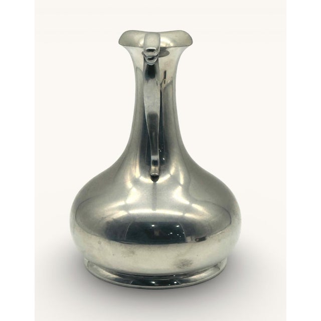 A Cartier pewter pitcher, stamped on the bottom. Vintage condition with a dent (shown in photos).