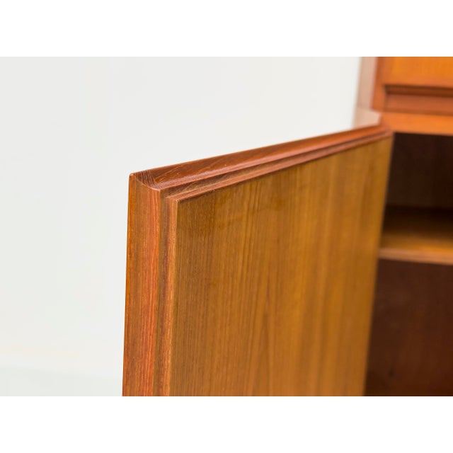 Exceptional danish highboard, consisting of two modules. teak-veneered body with solid teak doors and veneered panels....