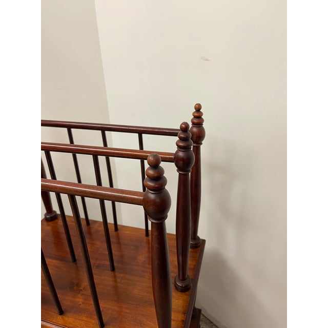 This traditional magazine rack features a refined spindle gallery with lathe-turned supports and finial-topped posts,...