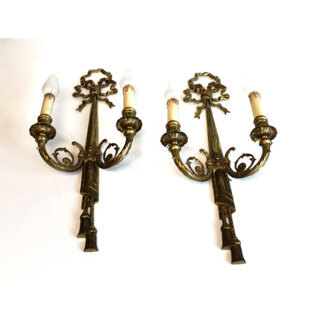 Pair of Louis XVI style gilt bronze wall sconces, with two light arms, richly decorated with scrolls and acanthus leaves....