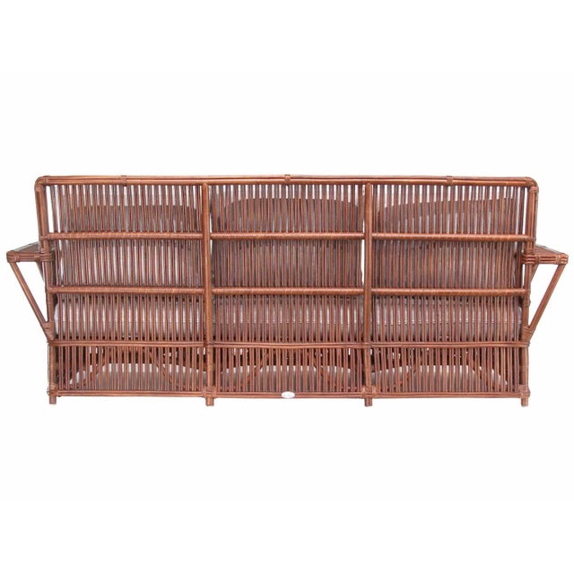 This beautifully stick rattan “Nantucket” three-seat sofa features classic Walnut Finished stick rattan framing with...