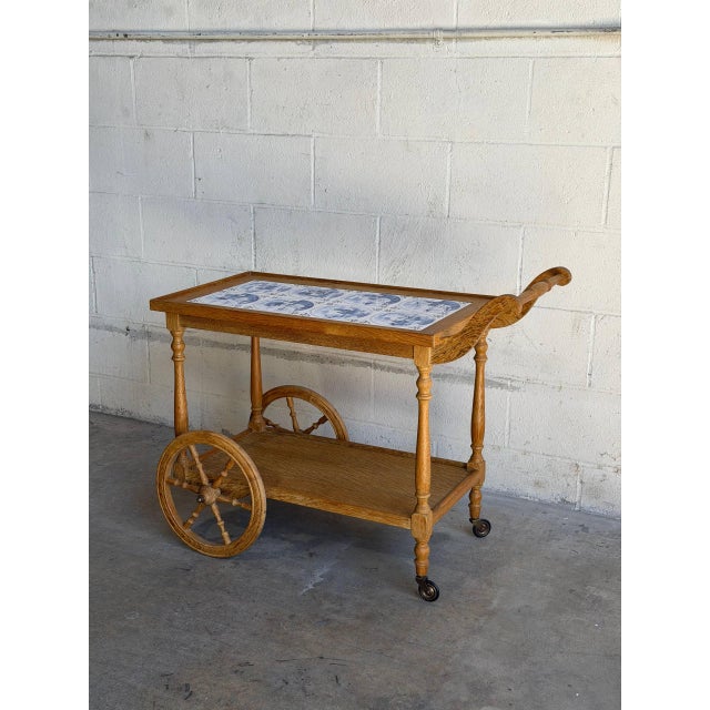 Beautiful vintage Danish serving cart crafted in solid oak with decorative blue and white ceramic tile top. This elegant...
