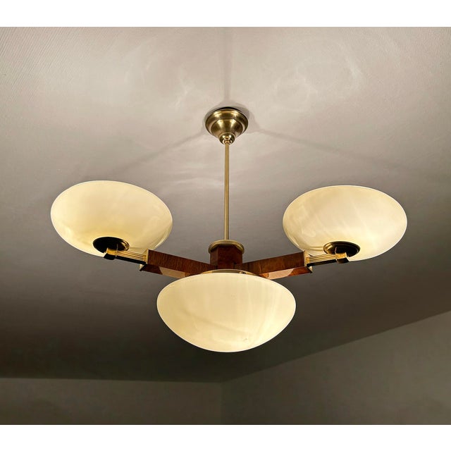 Large Art Deco pendant light from the 1930s, fully rewired, featuring a wood structure with brass and trim, large central...