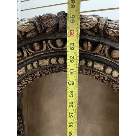 Description Highly decorative carved wood corner cabinet featuring an arched niche top and richly embellished surface with...