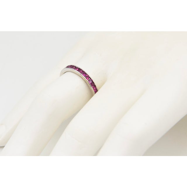 Channel Set Ruby 18K White Gold Eternity Band Ring A classic eternity-style band crafted in 18K white gold, set with a...