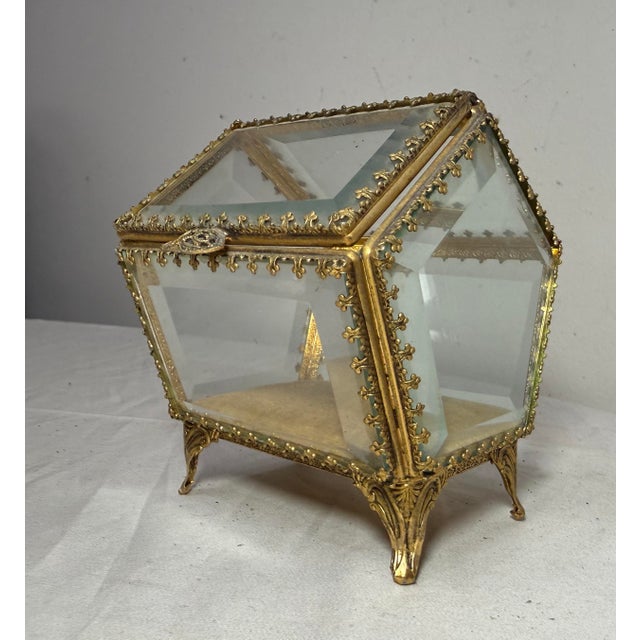 This antique gold gilded brass and beveled glass jewelry casket display is a handmade piece from France. It features...