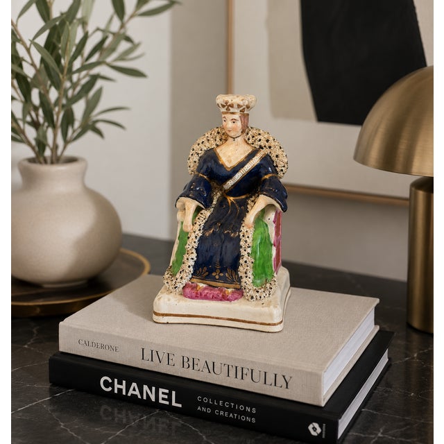 A very good antique Staffordshire flatback figure depicting Queen Victoria seated in a high-back chair, wearing a crown...
