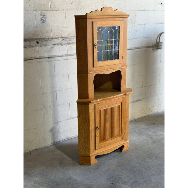 Beautiful vintage Brutalist corner cabinet in style of Henning Kjærnulf, crafted in solid oak with striking Scandinavian...