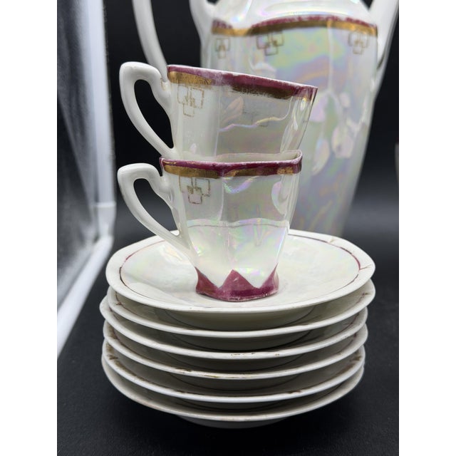Richard Ginori tea set from the 1930s in iridescent porcelain, with magenta enamel trim and gold designs. It includes: 6...