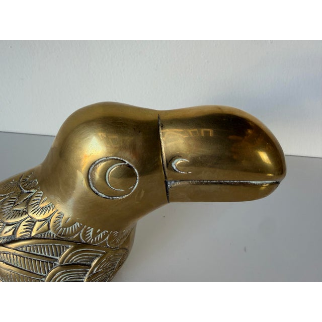Striking 1980s vintage solid brass toucan sculpture by Dolbi Cashier, featuring a sculptural curved beak and beautifully...