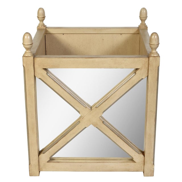 A neoclassical style painted wood and mirrored jardinière stand featuring a square form accented by bold architectural...