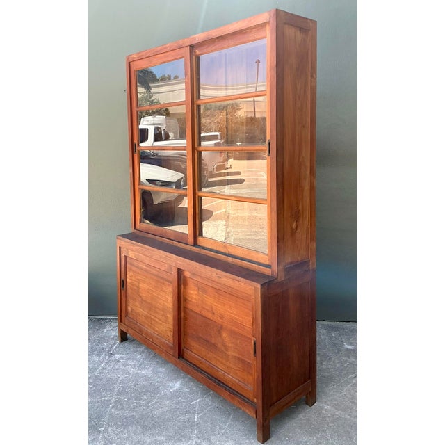 This striking vintage primitive teak cabinet is a masterclass in honest, utilitarian design. Handcrafted from solid teak...