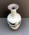 Handcrafted studio pottery vase decorated with birds in flight. The primary color is a light celadon with the birds...