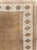 This Mid-20th century Turkish Anatolian carpet presents a restrained, earthy composition centered on a broad open field in...