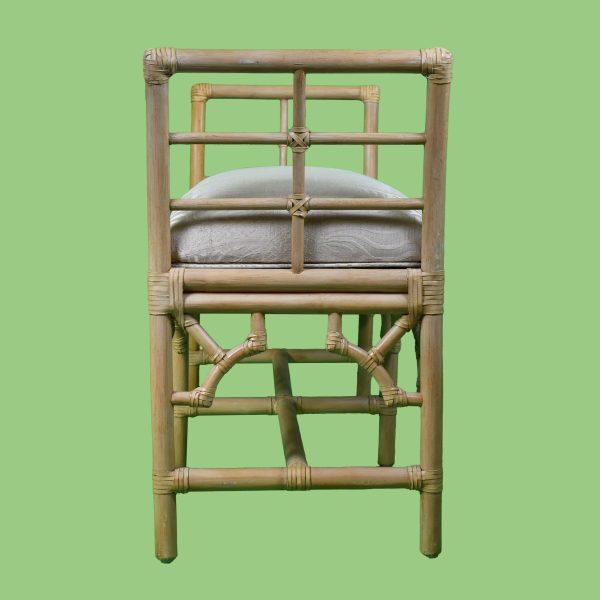 A charming vintage bench pairing intricate fretwork rattan with a comfortable upholstered seat. The airy openwork frame...