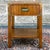 A vintage Dixie Campaigner collection pecan and brass nightstand having one dovetailed drawer over block legs and an open...