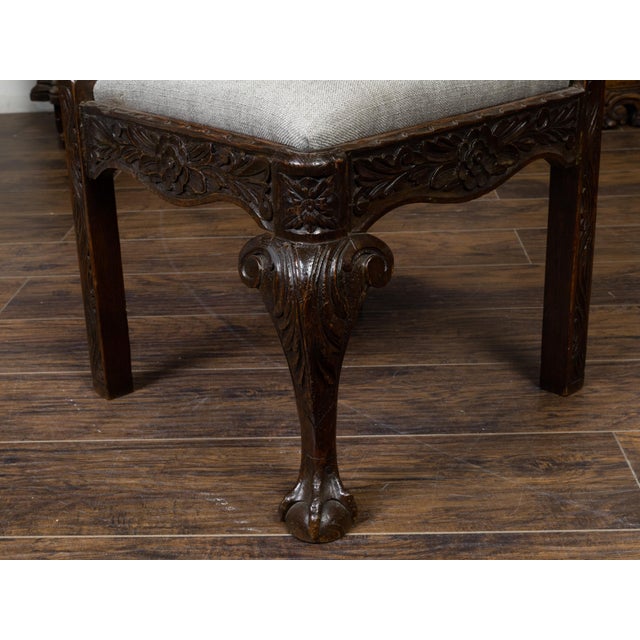 An English oak corner chair from the 19th century, with carved foliage, mascaron motifs and new upholstery. Created in...