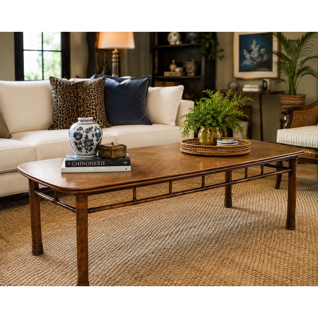 A striking vintage faux-bamboo cocktail table featuring a beautifully restored geometric veneer top and warm fruitwood...