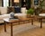 A striking vintage faux-bamboo cocktail table featuring a beautifully restored geometric veneer top and warm fruitwood...