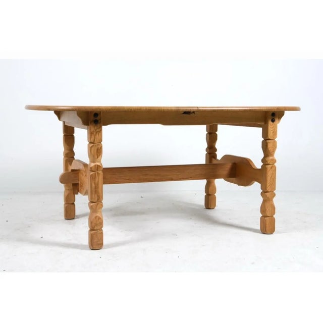 Oak extending dining table with an oval top. The table is raised on turned legs with carved detailing. Construction and...