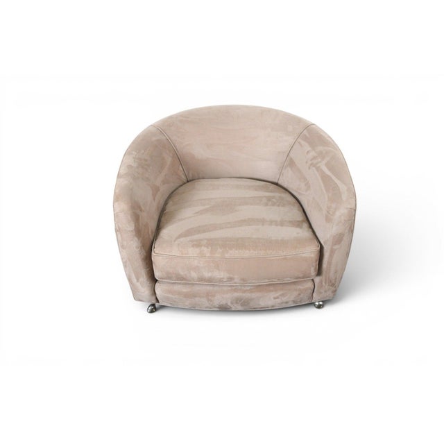 This tub chair reflects the sculptural, low-slung silhouette associated with Milo Baughman's American mid-century seating...