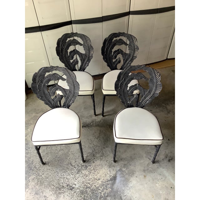 Black, cast aluminum dining set consisting of four chairs and a pedestal table with rounded square glass top made of 3/4...