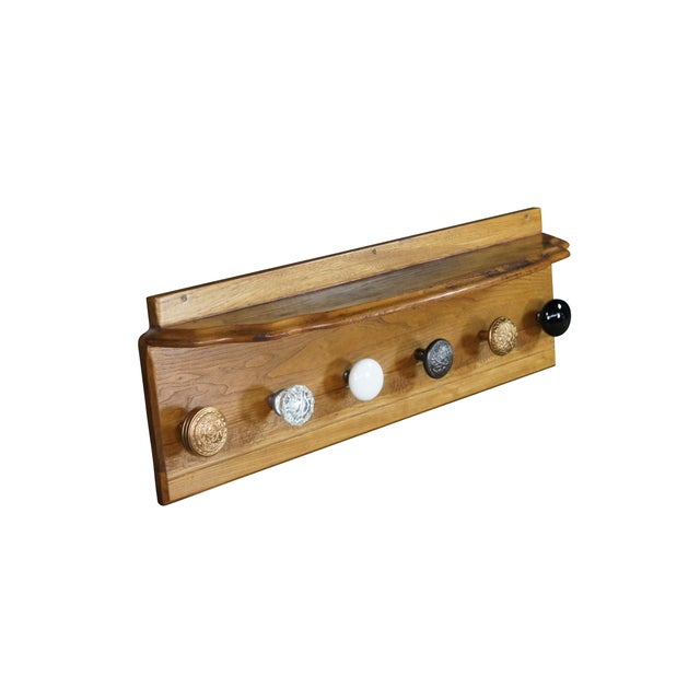 This custom-made antique coat rack features an elongated, clear-finished oak backboard supporting a narrow display shelf...