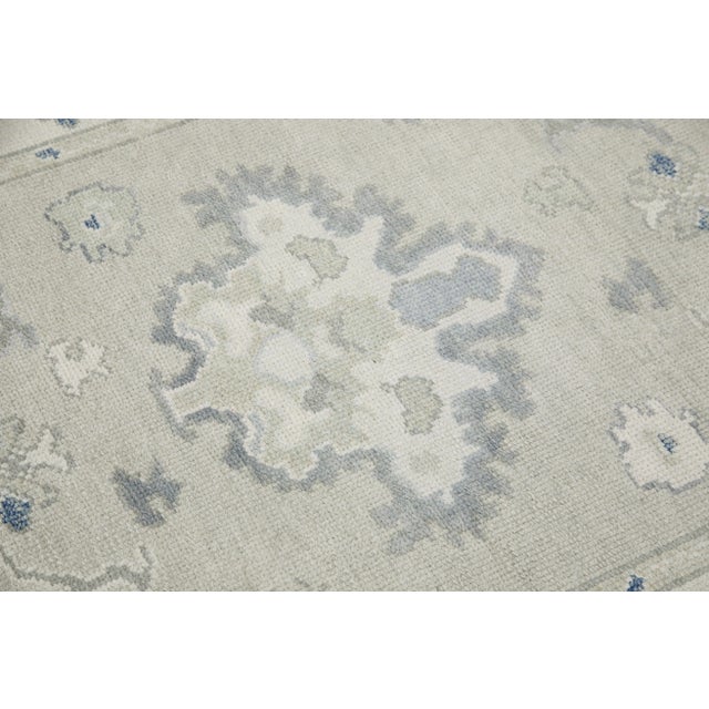 This modern Turkish Oushak rug is a stunning piece of art that has been handwoven using traditional techniques by skilled...