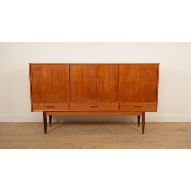 Almost two meters wide, yet remarkably airy in appearance. This beautiful Danish highboard from the 1960s is a fine...