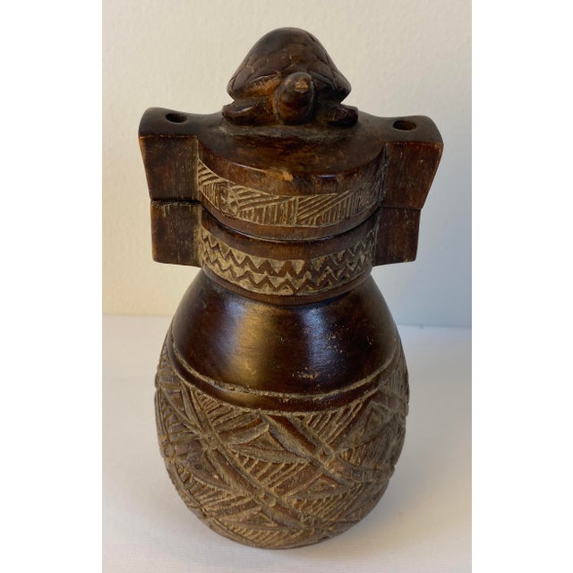Vintage carved wooden vessel featuring an intricate turtle finial and hand-carved geometric patterns throughout. The warm,...