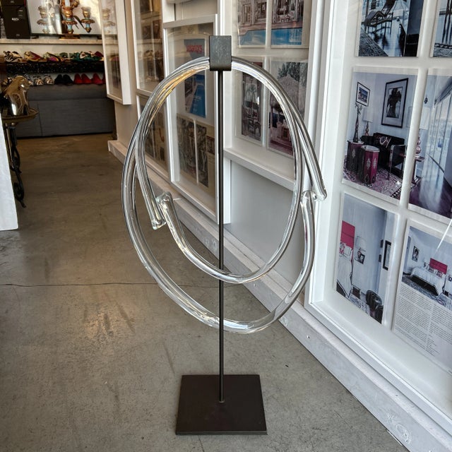Contemporary abstract blown glass sculpture. The circular glass parts just about meet but do not connect. A custom iron...