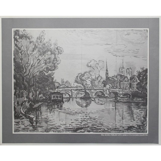 River Scene by Paul Signac is a refined exhibition print capturing the quiet beauty of a riverside cityscape, likely...