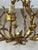 Elegant 1950s chandelier in gilded brass, featuring a finely crafted floral motif. Its airy design is composed of hammered...