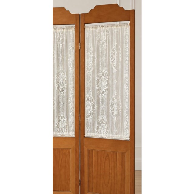 Beautiful vintage three-panel wooden folding room divider featuring a warm honey-toned finish, elegant scalloped tops, and...