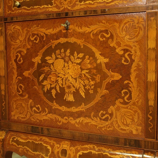 Great mid-20th century Italian bar cabinet. High-legged sideboard richly inlaid with floral decorations of great pleasure....