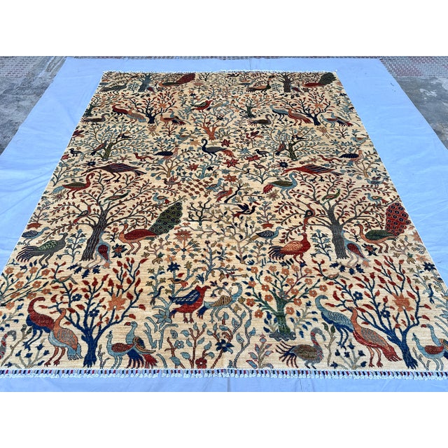 This extraordinary hand-knotted wool area rug features a spectacular, museum-quality Tree of Life pictorial design. The...